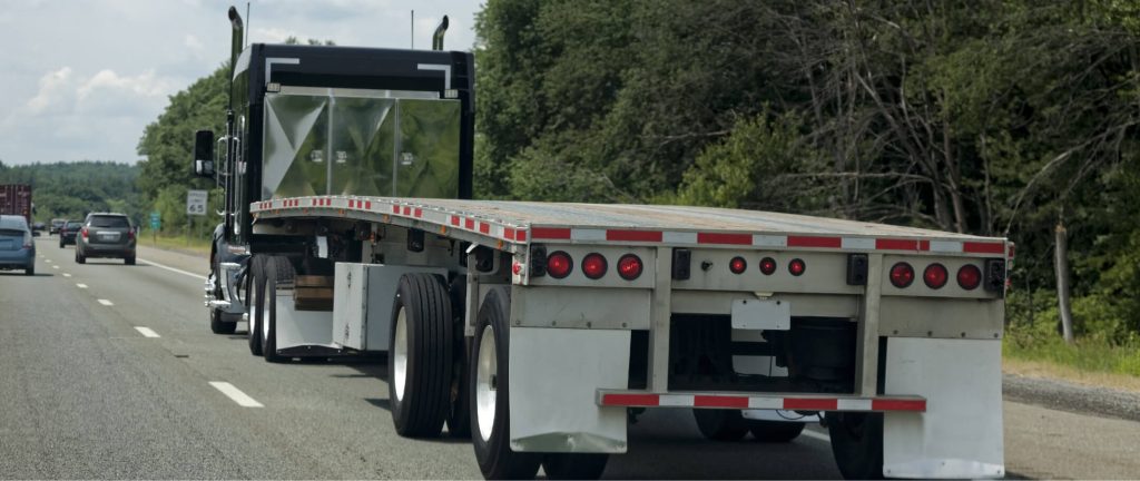 A flatbed trailer travelling on a multi-lane road.