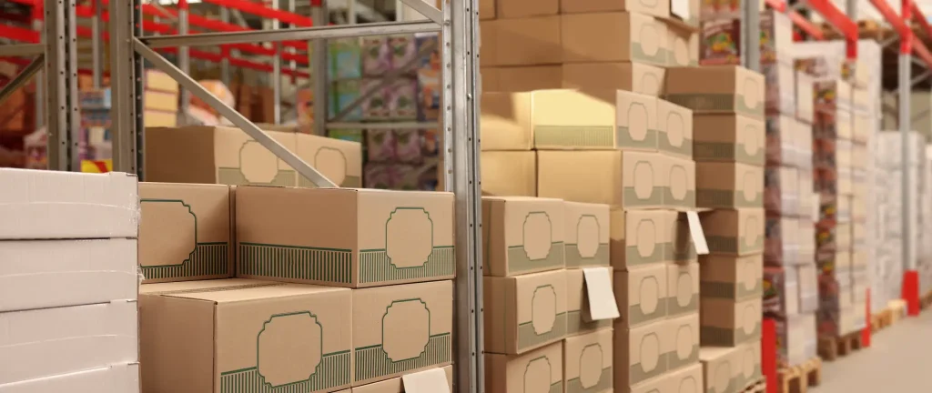 Cardboard boxes stacked on warehouse shelving — product storage and distribution logistics services